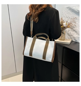 Minimalist canvas tote bag with brown straps shown on shoulder for daily commute