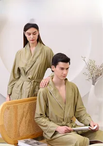 Detail of olive green waffle texture bathrobe with contrast white trim and pocket