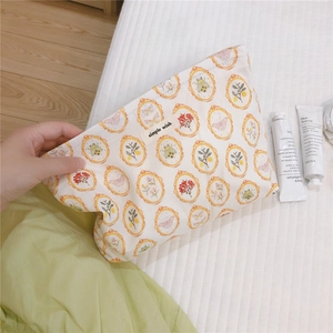 Detail of floral canvas makeup bag with vintage print and simple wish label
