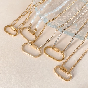 Assorted gold stainless steel necklaces with oval carabiner pendants and varied chains