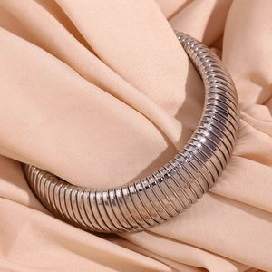 Macro shot of 20mm wide silver snake chain bracelet on champagne silk fabric background