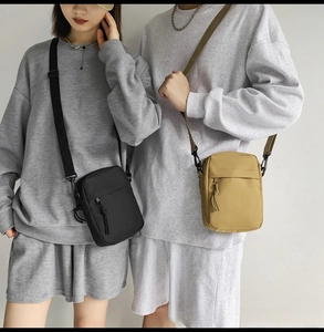 Detail of minimalist nylon crossbody bags in black and khaki with adjustable straps