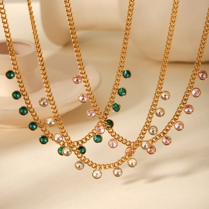 Close-up of gold stainless steel necklaces with green, pink, and clear zircon pendants