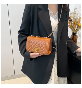 Detail of brown quilted faux leather crossbody bag with gold chain and metal lock