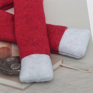 Close-up of red felt Christmas chair leg covers with white cuffs in a warm setting