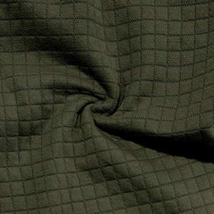 Macro shot of olive green waffle knit fabric texture on a casual men's jacket