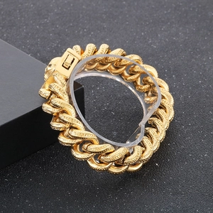 Close-up of golden punk skull chain bracelet with engraved textures and square clasp detail