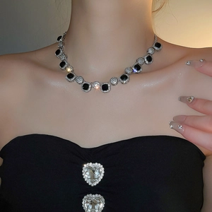 Macro view of a necklace featuring a black square gem with a sparkling crystal halo