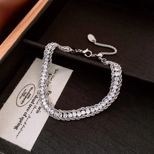 Close-up of a silver mesh bracelet with rows of white zircon and adjustable pull-chain