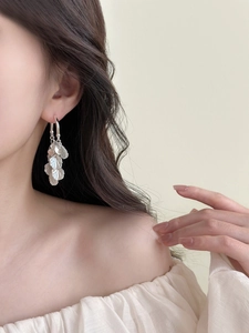 Silver drop earrings featuring multi-layered metal leaf fringe shown on a model