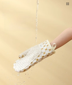 Washable kitchen oven mitt with yellow floral pattern being cleaned under running water