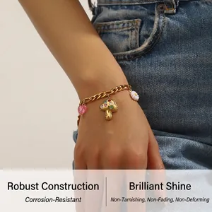 Detail of a gold stainless steel chain bracelet with colorful mushroom and flower charms
