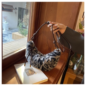 Détail du sac croissant en fausse fourrure léopard avec bandoulière en cuir noué chic