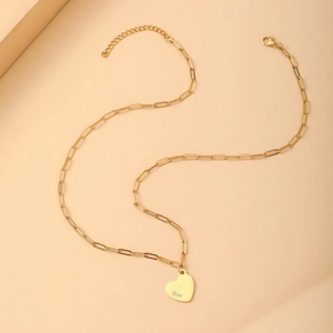 Detail of gold heart pendant with Son engraving on a stylish paperclip chain necklace
