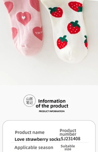 Detail of pink knitted socks featuring strawberry and heart patterns in soft cotton blend