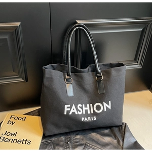Detail der schwarzen Canvas-Tragetasche mit Ledergriffen und Fashion Paris Print