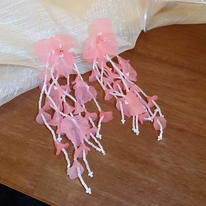 Detailed view of pink floral tassel earrings with mesh petals and delicate white beads