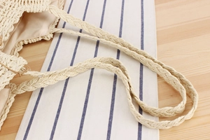 Close-up of bohemian straw tote bag showing detailed weave texture and fabric lining
