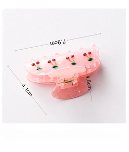 Detail view of pink PVC hair claw clip with cherry decor and dimensions 7.9cm x 4.5cm