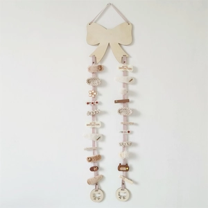 Pink ribbon hair clip holder with a wooden bow plate displaying various cute hair clips