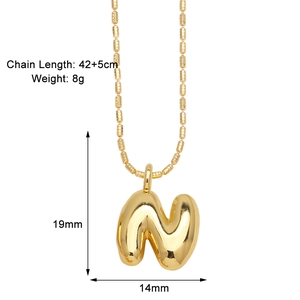 Detail of puffy golden letter N pendant with size measurements 19mm by 14mm on bead chain