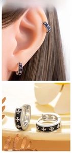 Détail de boucles d'oreilles croix en émail noir et de bagues d'oreilles gothiques