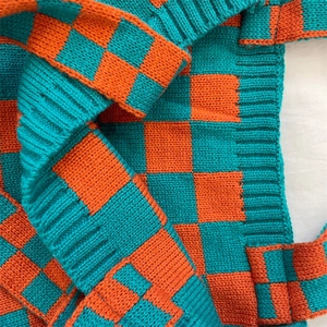 Close-up of teal and orange knitted checkerboard tote bag showing detailed fabric texture