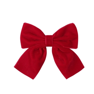 Detailed view of red velvet bow hair clip showing soft fabric texture and elegant design