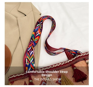 Close-up of bohemian woven bag featuring a colorful geometric wide shoulder strap and tassels