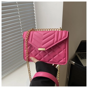 Detail of rose red quilted PU leather bag featuring gold chain strap and metal clasp