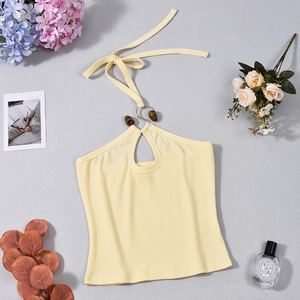Λεπτομέρεια κίτρινου ριμπ πλεκτού halter top με άνοιγμα στο στήθος και μεταλλικό κρίκο
