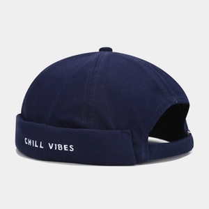 Detail of dark blue brimless docker hat featuring white Chill Vibes letter embroidery