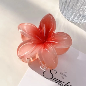 Détail d'une pince à cheveux en forme de fleur avec dégradé rose et texture en résine lisse