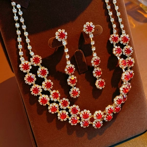 Detail of red flower pendant necklace and earrings set on brown velvet display stand