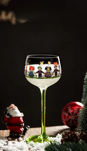 Detail view of Alsace-style wine glass with green stem and folk art illustrations
