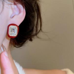 Macro detail of geometric square stud earring with red enamel and sparkling zircon