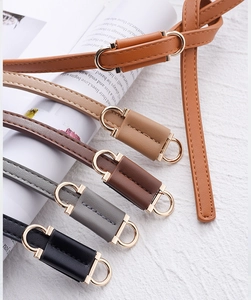 Detail of five assorted PU leather skinny belts featuring elegant golden double ring buckles