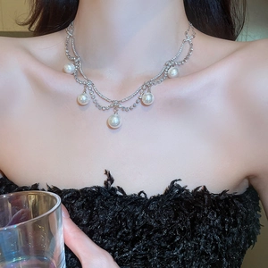 Detail of elegant double-layered pearl necklace with rhinestones worn on a collarbone