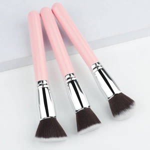 Detailed macro shot of three pink makeup brushes with dual-tone synthetic bristles