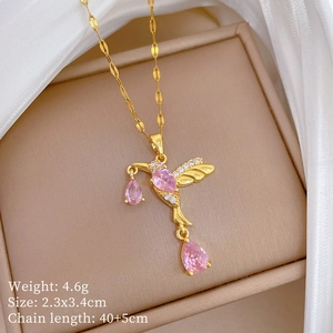 Macro detail of hummingbird pendant with pink gemstones in a jewelry box on white silk