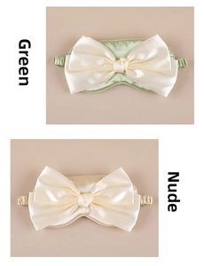 Detailed close-up of green and beige satin sleep eye masks with decorative large bows