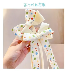 Close-up of colorful polka dot bow hair clips with long ribbons for girls' hairstyles
