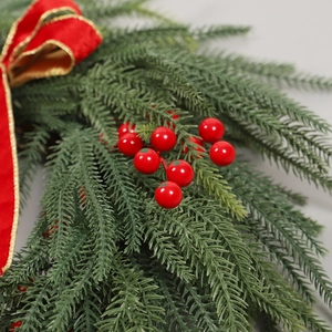 Couronne de Noël avec aiguilles de pin vertes, baies rouges et nœud en velours bordé d'or