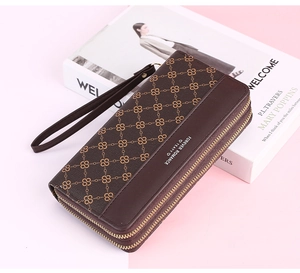 Close-up of brown quilted long wallet with double zippers and elegant wristlet strap
