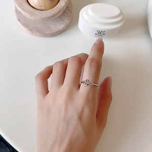 Modern S925 sterling silver hollow cross open ring shown on hand in a stylish setting