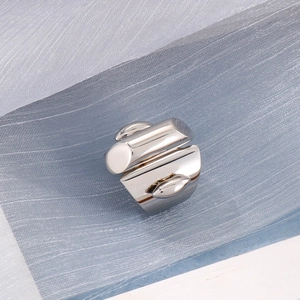 Close-up of geometric stainless steel ring on blue mesh background in 45-degree view