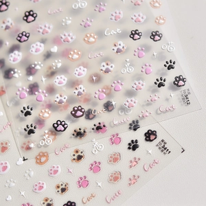Detailed macro view of 3D embossed cat claw nail stickers in pink and black tones