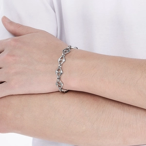 Detailed view of a silver stainless steel anchor link bracelet worn on a wrist