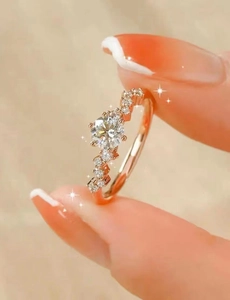 Macro view of rose gold engagement ring with wave-patterned diamond setting on hand