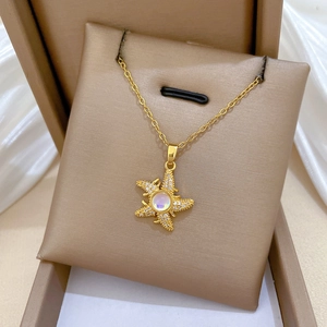 Macro detail of a golden starfish pendant with crystals on a jewelry box cushion